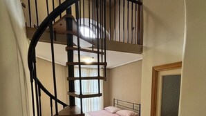 A compact room with a spiral staircase leading to an upper level. - Mansion of the Valentines (Napoli)