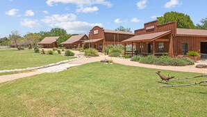 Un hôtel de style rustique composé de plusieurs bâtiments en bois, doté d’une pelouse bien entretenue et offrant une vue sur un ciel dégagé.