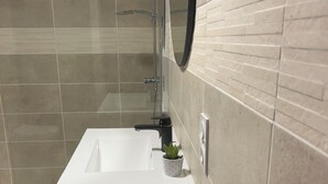 A modern bathroom with a glass-enclosed shower, a white sink, and a small potted plant. - T2 apartment in condominium (Villa) with pool access (Fréjus)