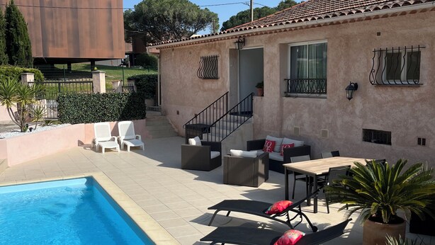 A swimming pool, outdoor seating, and a building with a tiled roof. - T2 apartment in condominium (Villa) with pool access (Fréjus)