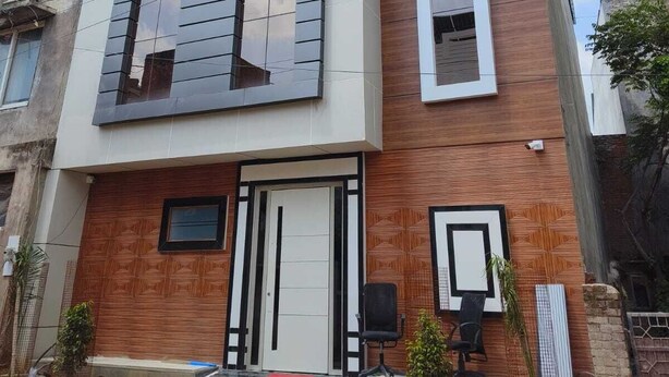 A modern two-story building with a flat roof, large windows, and a wooden facade. - Hotel Pravas Inn (Lucknow)