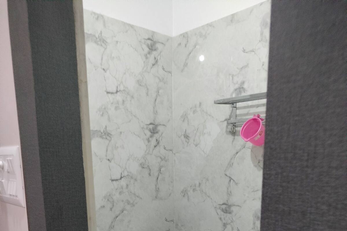 Un baño con inodoro, bidé y pared de mármol.
