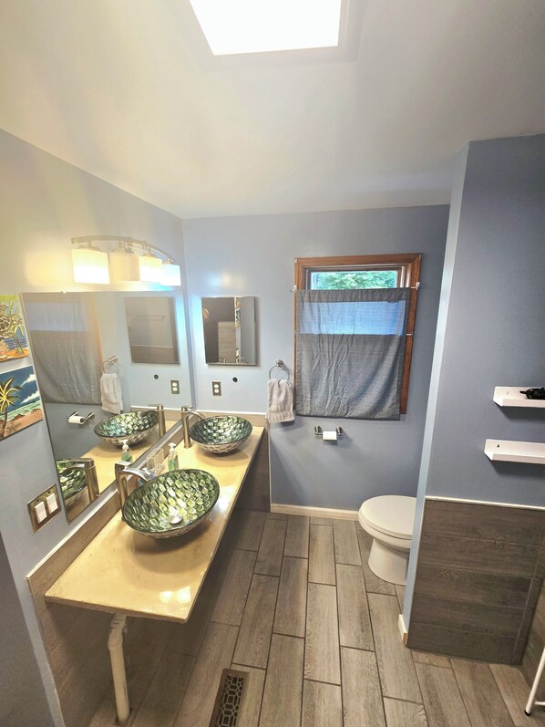 A bathroom with two sinks, a toilet, and a window. - Eckerman / Strongs vacation home (Eckerman)