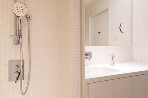 A bathroom with a shower, a sink, and a mirror. - Vienna Residence, Philips Haus - Euro Plaza #6536 (Vienna)