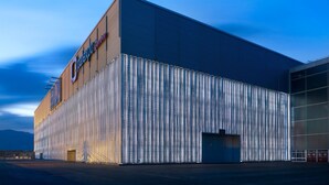 Ein großes Industriegebäude mit einer Wellmetallfassade und einem Schild mit der Aufschrift 'Cpaoxpo Garage'.