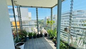 Ein Dachgarten mit Kübelpflanzen und Blick auf die Stadtlandschaft.