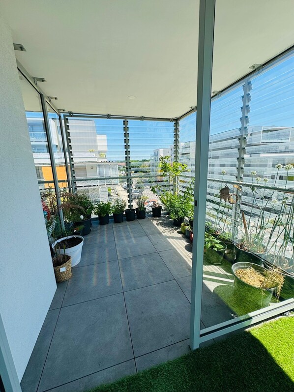 A rooftop garden with potted plants and a view of the cityscape.