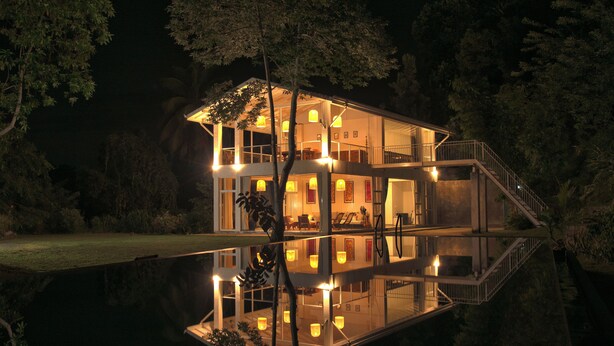 A multi-level house with a reflective pool in front, surrounded by trees. - Colonial-style bungalow with private pool, mountain views  and tranquil vibes. (Kandy)