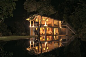 A multi-level house with a reflective pool in front, surrounded by trees. - Colonial-style bungalow with private pool, mountain views  and tranquil vibes. (Kandy)
