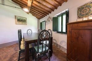 A dining area with a wooden table, chairs, and a cabinet.