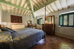 A bedroom with a bed, a dresser, a mirror, and a window.