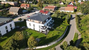 Ett flygbildsbild av ett bostadsområde med moderna hus, en kyrka och en välskött grönområde.