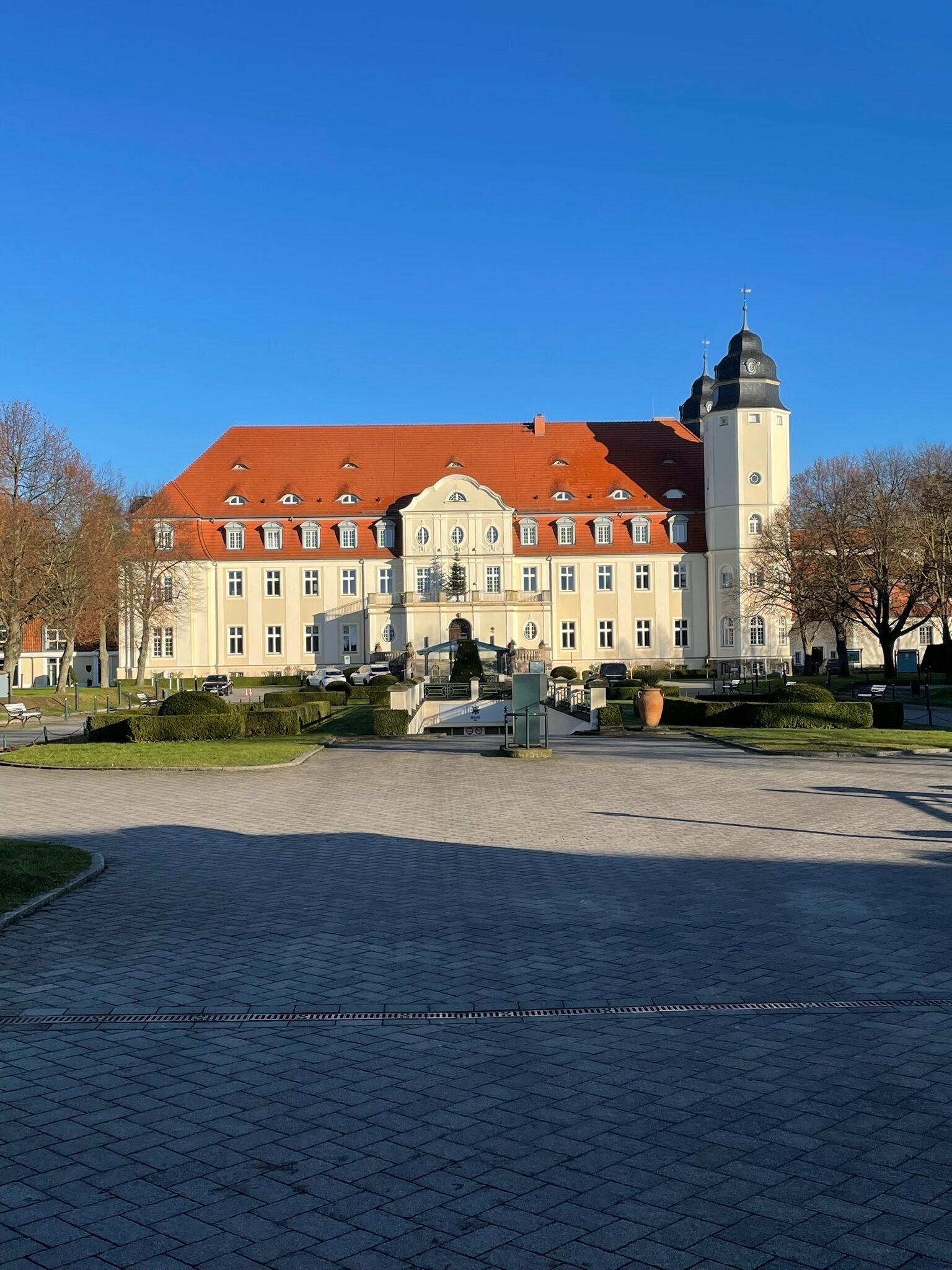 Ein großes, historisches Gebäude mit rotem Ziegeldach und einem markanten Turm.