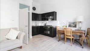 A compact living space with a kitchenette, a dining area, and a sofa.