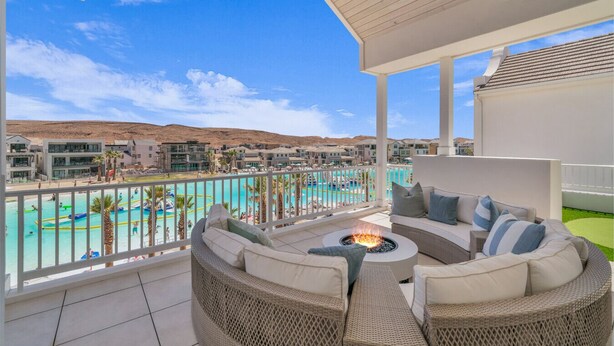 Un balcón con vistas a una piscina, un brasero y mobiliario exterior.