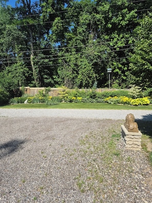 A gravel driveway leading to a building with a stone lion statue. - Ideal for traveling professionals. Private 2-bedroom home in peaceful Mansfield. (Mansfield)