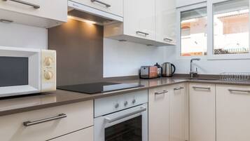 Een microgolfoven, een oven, een kookplaat, een vaatwasser