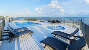 A pool area with lounge chairs and a hot tub, overlooking the sea. - Stylish Oceanview Kayak Getaway w/ Pool & Hot Tub! (Key Largo)