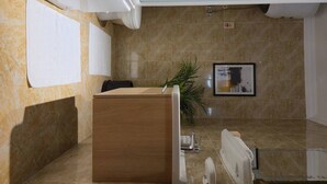 A modern bathroom with a wooden vanity, a sink, and a mirror. There is a framed picture on the wall and a plant in the corner. - Madinaty Botanic Bliss (Cairo Governorate)