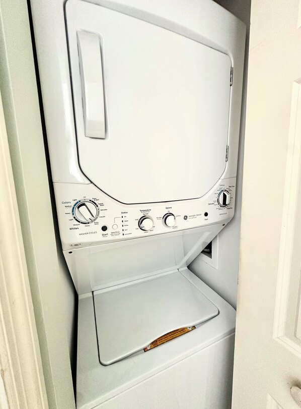A compact washer and dryer unit with control knobs, a start button, and a detergent dispenser.