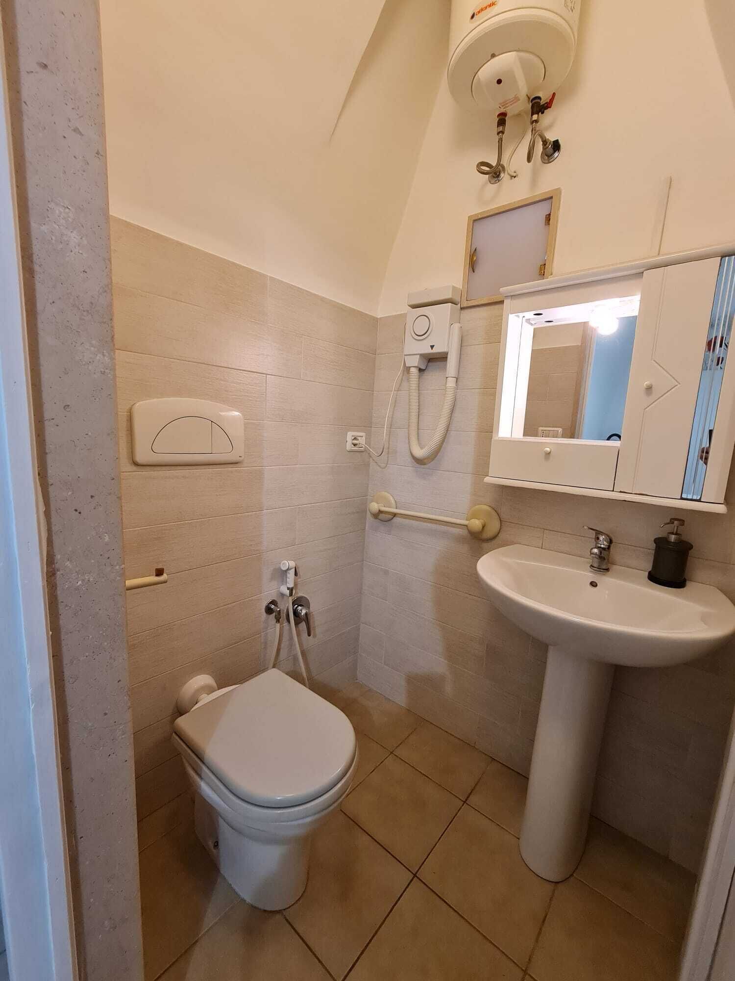 Ein Badezimmer mit Toilette, Bidet, Waschbecken und Spiegel.