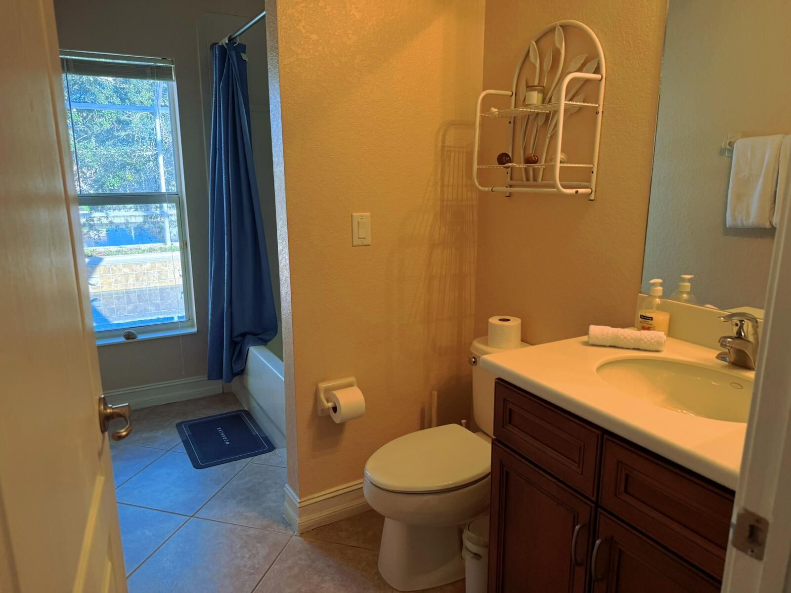 A bathroom with a toilet, sink, and shower area.
