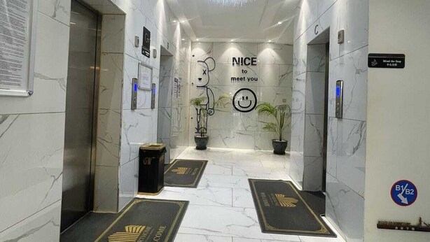 A modern hotel lobby with marble floors, a central chandelier, and a welcome mat. - Pazoori Stays at SmartHomes (Nairobi)
