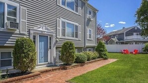Um edifício residencial de dois andares com um caminho de tijolos que leva à porta da frente.