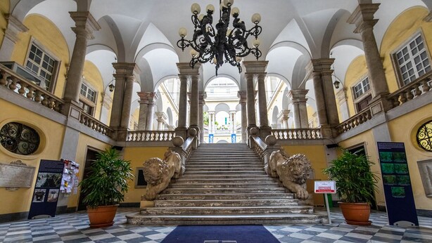 A grand staircase with lion statues, leading to a high ceiling with a chandelier. - ROSA HOMES - THE GREEN  (Genoa)