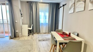 A modern dining area with a white table, grey chairs, and a grey rug. - D'Moda lodging. Bright apartment in the center of Ribadeo. (Ribadeo)