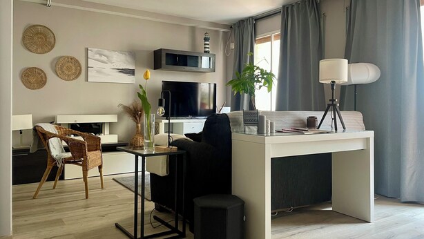 A modern living room with a central desk, a television, a lamp, and a plant. - D'Moda lodging. Bright apartment in the center of Ribadeo. (Ribadeo)