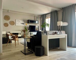 A modern living room with a central desk, a television, a lamp, and a plant. - D'Moda lodging. Bright apartment in the center of Ribadeo. (Ribadeo)