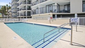 A swimming pool with a lifeguard sign, surrounded by a multi-story building with balconies. - Oceanfront Three Bedroom Condo - Crescent Sands C-4-September discounted! (North Myrtle Beach)