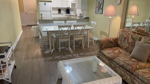 A compact living space with a dining area, kitchenette, and a sofa. - Oceanfront Three Bedroom Condo - Crescent Sands C-4-September discounted! (North Myrtle Beach)