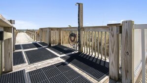 A wooden deck with black rubber mats, a wooden fence, and a hose. - Oceanfront Three Bedroom Condo - Crescent Sands C-4-September discounted! (North Myrtle Beach)