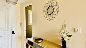 Een moderne keuken met een houten aanrecht, een zwarte vaas met bloemen en een decoratief wandobject.