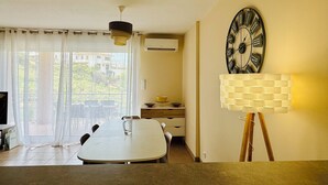 Een moderne eetruimte met een grote tafel, een wandklok en een lamp.