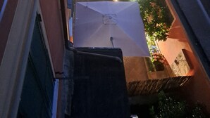 A rooftop terrace with a small garden, a seating area, and a water feature.