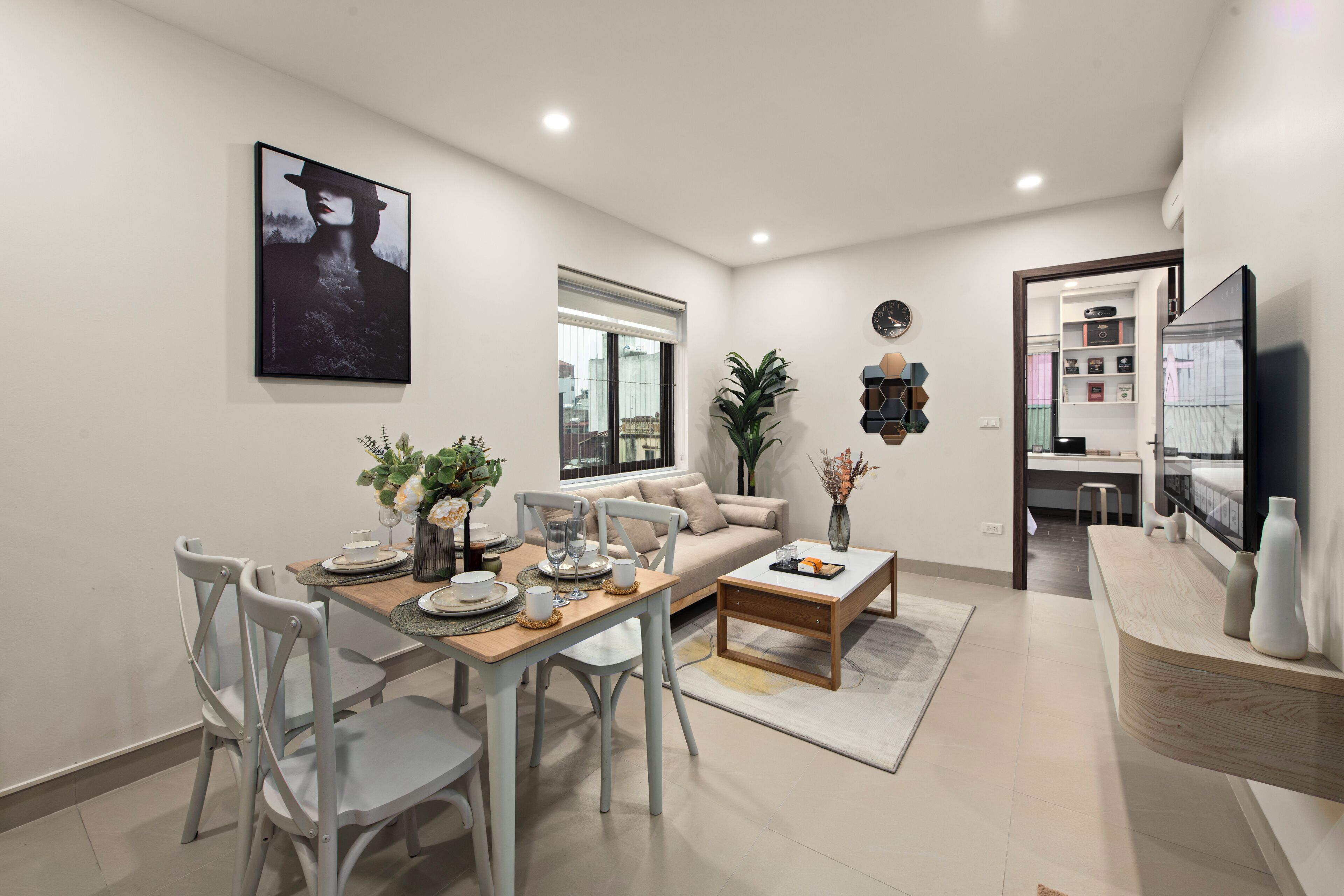 A modern living room with a dining area, a sofa, a coffee table, and a TV.