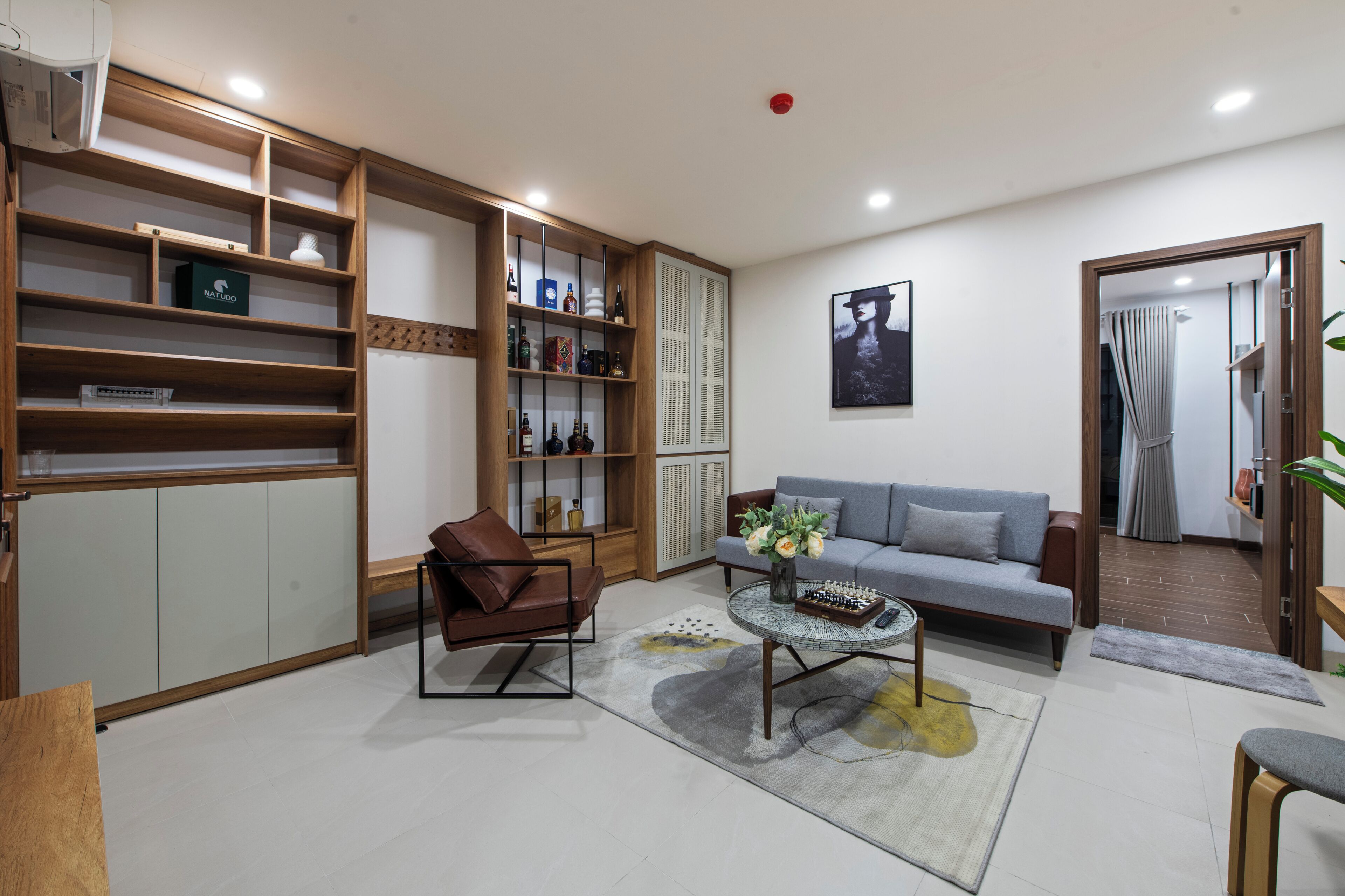 A modern living room with a sofa, coffee table, and a bookshelf.