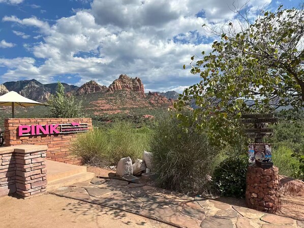 A sign for Pink Adventure Park with a view of red rock formations in the background.