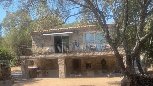 A stone building with a balcony, outdoor seating, and a tree in the foreground. - Guest room 25m2 (Figari)