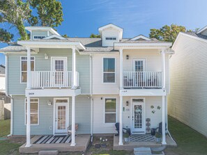A two-story house with a front porch, a garage, and a small balcony on the upper floor.
