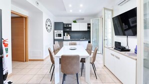 A modern kitchen with white cabinets, a built-in oven, and a microwave.