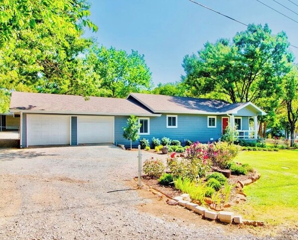A single-story house with a garage, a front porch, and a well-maintained garden. - Lake Cottage 200 yards from the Lake Texoma shoreline! (Pottsboro)