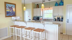 A kitchen with a central island, white cabinetry, and a 'lobsters' sign.