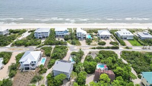 A coastal property with multiple buildings, a swimming pool, and a beach view.