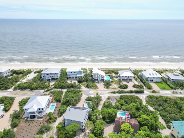 A coastal property with multiple buildings, a swimming pool, and a beach view.