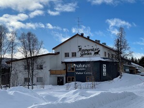 Ein Gebäude mit einem Schild, auf dem 'Amarnäs Garden' und 'Naturum Besucherzentrum' steht, vor einer verschneiten Landschaft.