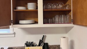 A kitchen with wooden cabinets, a granite countertop, and a box labeled "you are my sunshine" with kitchen utensils. - Charming 4-bedroom house with WiFi, AC in wonderful Sundance (Sundance)